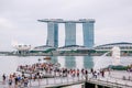 Crowds of tourists admire the view of Marina Bay Sands hotel and The Merlion fountain