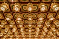 Close up of ornamental ceiling in buddhist temple made of rows of golden lanterns