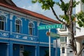 Joo Chiat Road street sign against blue shophouse, on a sunny afternoon Royalty Free Stock Photo