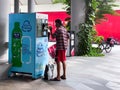 Singapore Sep2020 Man recycling plastic bottle in a reverse vending machine. Earn while recycling empty cans, plastic bottles;