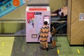 Singapore Sep2021 Woman and child using TraceTogether Token Replacement Vending Machine in shopping mall. TraceTogether app or