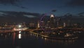 Singapore - 25 September 2018: Aerial view of big city with many lights, cloudy sky, and ferris wheel at night. Shot Royalty Free Stock Photo