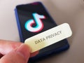Singapore - September 2023: A note showing Data Privacy and an off focus image of a mobile phone showing Tiktok logo