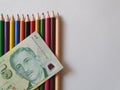 Singaporean money and color pencils on the white background