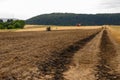 Singed grass on agricultural road with burnt out hay baler in field Royalty Free Stock Photo