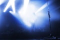 singer in the blue light of spotlights on the stage of a music festival. the concert lead goes to the microphone.