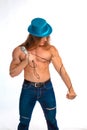 Singer bodybuilder shirtless with long hair in a blue hat with a microphone