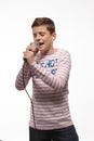Singer brunette boy in a pink jumper with a microphone and headphones Royalty Free Stock Photo
