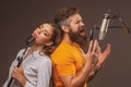 Singer couple singing rock. Sound producer recording song in a music studio. Excited duet Karaoke. Royalty Free Stock Photo