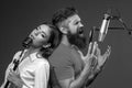 Singer couple singing rock. Sound producer recording song in a music studio. Excited duet Karaoke. Royalty Free Stock Photo