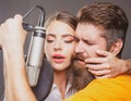 Singer couple singing rock. Sound producer recording song in a music studio. Sexy man and woman singing with music Royalty Free Stock Photo