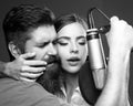 Singer couple singing rock. Sound producer recording song in a music studio. Sexy man and woman singing with music Royalty Free Stock Photo