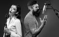 Singer duet couple is performing a song with a microphone while recording in a music studio. Royalty Free Stock Photo