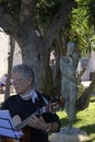 Singer of Neapolitan songs in public performance in front of a statue of mother with child