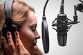 Singer or radio host working in a recording studio with a microphone in headphones close-up, blogging, radio, recording an album Royalty Free Stock Photo