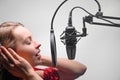 Singer or radio host working in a recording studio with a microphone in headphones close-up, blogging, radio, recording an album Royalty Free Stock Photo