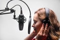 Singer or radio host working in a recording studio with a microphone in headphones close-up, blogging, radio, recording an album Royalty Free Stock Photo