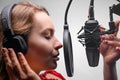 Singer or radio host working in a recording studio with a microphone in headphones close-up, blogging, radio, recording an album Royalty Free Stock Photo