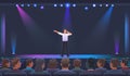 Singer sings on stage in the concert hall. A man sings a song in front of an audience seated in a hall