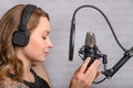 Singer with a tattoo sings rock music in the studio into a microphone, musician and treble vocals