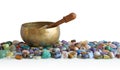 Singing bowl resting on bed of tumbled healing stones