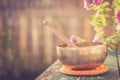 Singing bowl on a rustic wooden table with flowers, zen, outdoors Royalty Free Stock Photo