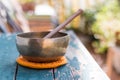 Singing bowl on a rustic wooden table with flowers, zen, outdoors Royalty Free Stock Photo