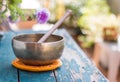 Singing bowl on a rustic wooden table with flowers, zen, outdoors Royalty Free Stock Photo