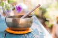 Singing bowl on a rustic wooden table with flowers, zen, outdoors Royalty Free Stock Photo