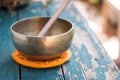 Singing bowl on a rustic wooden table with flowers, zen, outdoors Royalty Free Stock Photo