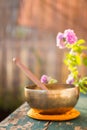 Singing bowl on a rustic wooden table with flowers, zen, outdoors Royalty Free Stock Photo