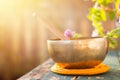 Singing bowl on a rustic wooden table with flowers, zen, outdoors Royalty Free Stock Photo