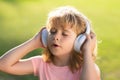 Singing children. Young child boy with headphones listening to music, enjoying favorite music with closed eyes outdoor. Royalty Free Stock Photo