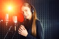Singing girl sing to the professional microphone in the record studio. Process of create a new hit song by young singer Royalty Free Stock Photo