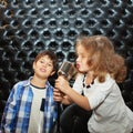 Singing little children with a microphone on a rack Royalty Free Stock Photo
