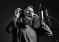 Singing man in a recording studio. Expressive bearded man with microphone. Expression face close up. Karaoke signer Royalty Free Stock Photo