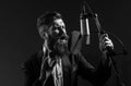 Singing man in a recording studio. Music festival. Expressive bearded man with microphone. Karaoke signer, musical Royalty Free Stock Photo