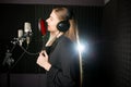 Singing young girl in recording studio.