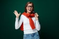 Singing young woman holding microphone on green background