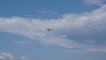 Single airplane flying in a cloudy bright sky