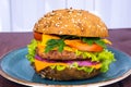 Single american burger with cheddar cheese, meat and fresh vegetables