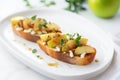 a single apple gorgonzola bruschetta on a minimalist white platter