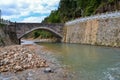Stone Arch Bridge Spanning River with White?Railed Retaining Wall Royalty Free Stock Photo