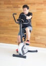 Single Asian Man On Excercise Bike At Fitness Center.