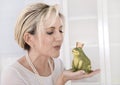 Single attractive older woman with a frog king in her hands. Royalty Free Stock Photo