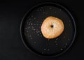 A Single Bagel with Sesame on dark plate Royalty Free Stock Photo