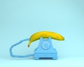 Single banana against blue retro telephone on bluish background. Royalty Free Stock Photo