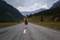 Single barefoot woman is walking along the mountain road. Travel, tourism and people concept Royalty Free Stock Photo