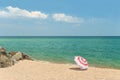 Single beach umbrella on empty beach with rocks Royalty Free Stock Photo