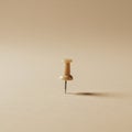 A single beige pushpin stands upright on a neutral beige surface, casting a subtle Royalty Free Stock Photo